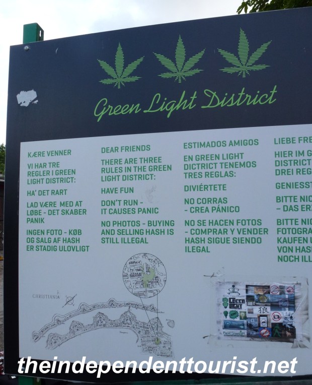 A sign in four languages welcoming visitors to Christiania and explaining the rules.