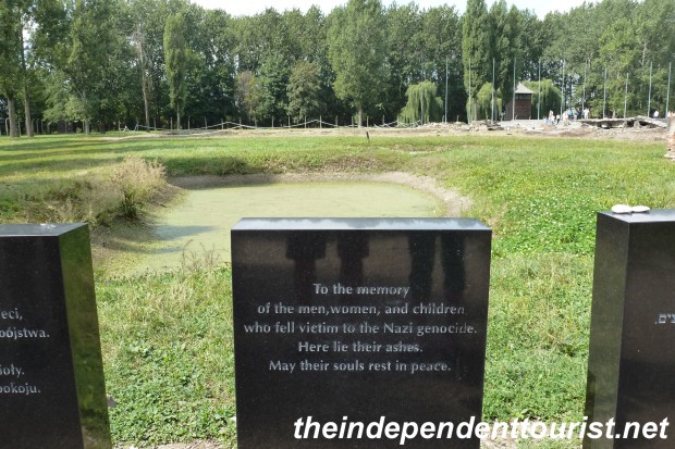 A plaque noting the pond in the background, where the ashes of thousands were dumped from the crematoria.