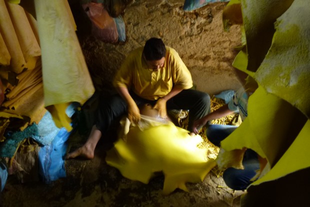 A worker doing some final processing of the leather before it turns into a product for sale.